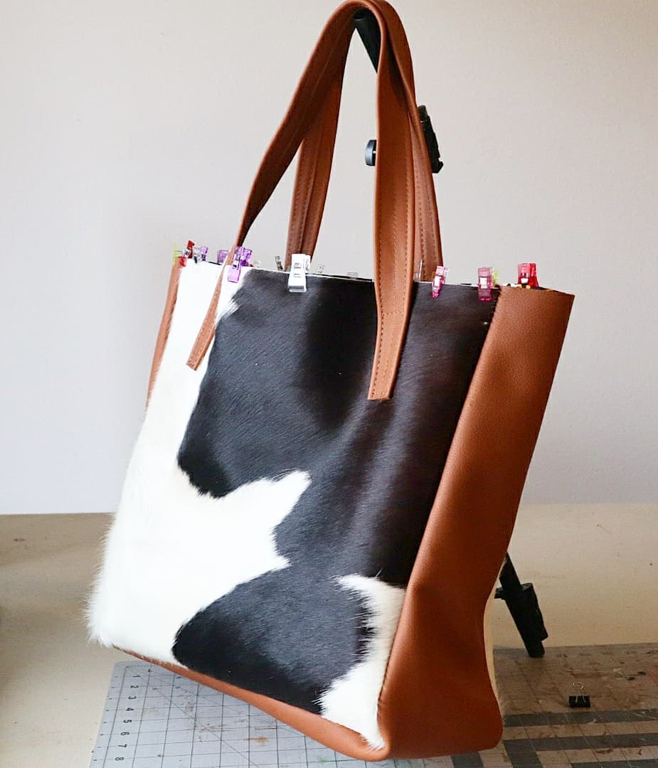 A leather and cowhide Uwakstar tote being assembled by hand on the workbench